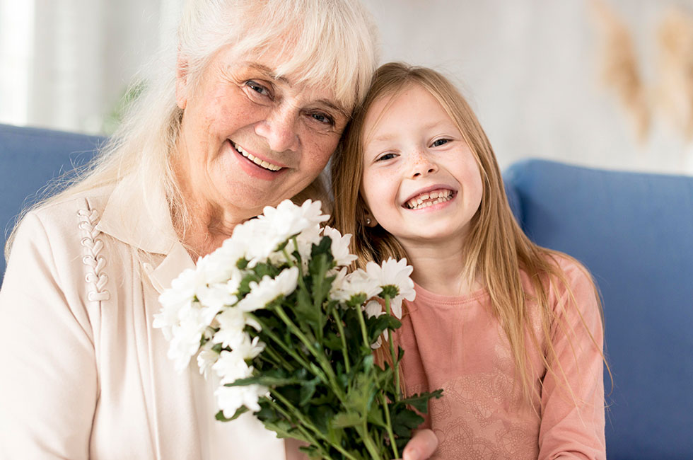 Grand-mère avec sa petite fille et un bouquet de fleurs